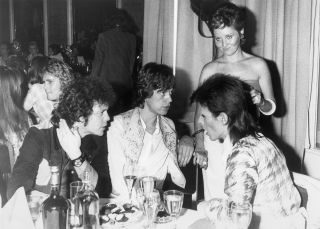 (Original Caption) 7/4/1973 - London, England - At the party given by pop star David Bowie at the Cafe Royal here following Bowie's final public concert. (L to R) American singer Lou Reed, Mick Jagger and David Bowie. Standing is Lulu.
