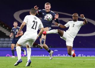 Scotland’s Oliver McBurnie, centre, and Israel’s Eli Dasa, right, battle for the ball during the UEFA Euro 2020 Play-Off semi final