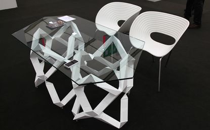 Glass gallerists’ table with white legs and chairs legs