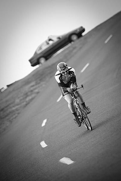 A tour official watches from his car as a rider descend into the finish in Portarlington.