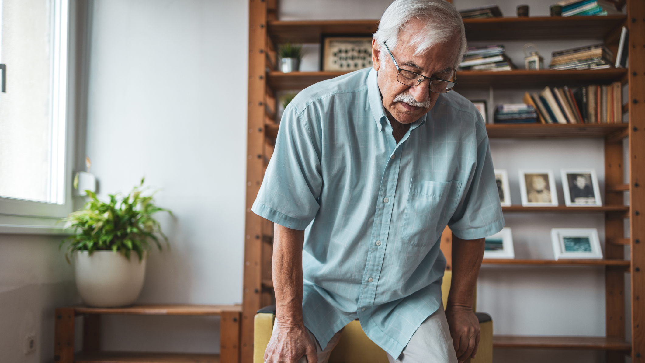 Senior man getting up from chair