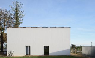 Alternative exterior view of Casa Modesta, two bikes and surrounding greenery under a blue sky