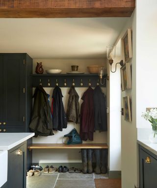 boot room with hooks for coats and closet storage