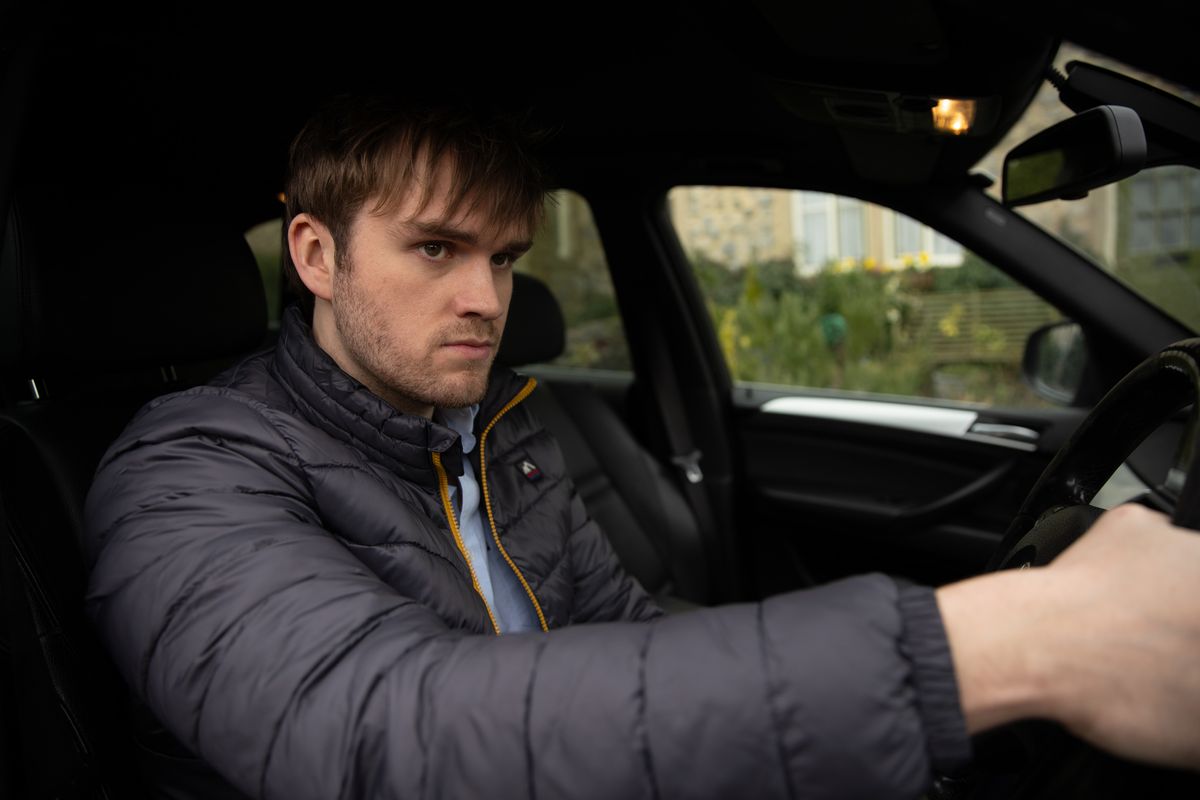 Tom looking cross in his car in Emmerdale 