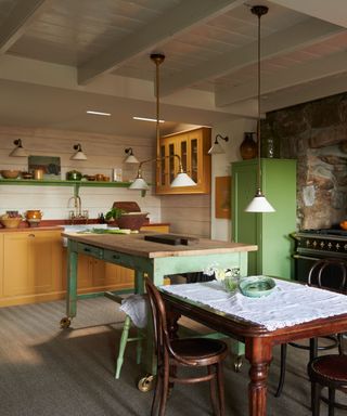 green and yellow living kitchen with multiple light sources and a central table