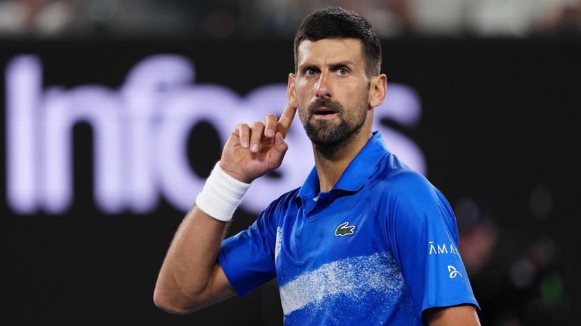 Novak Djokovic makes a &#039;listen&#039; gesture by his ear during an Australian Open 2025 match