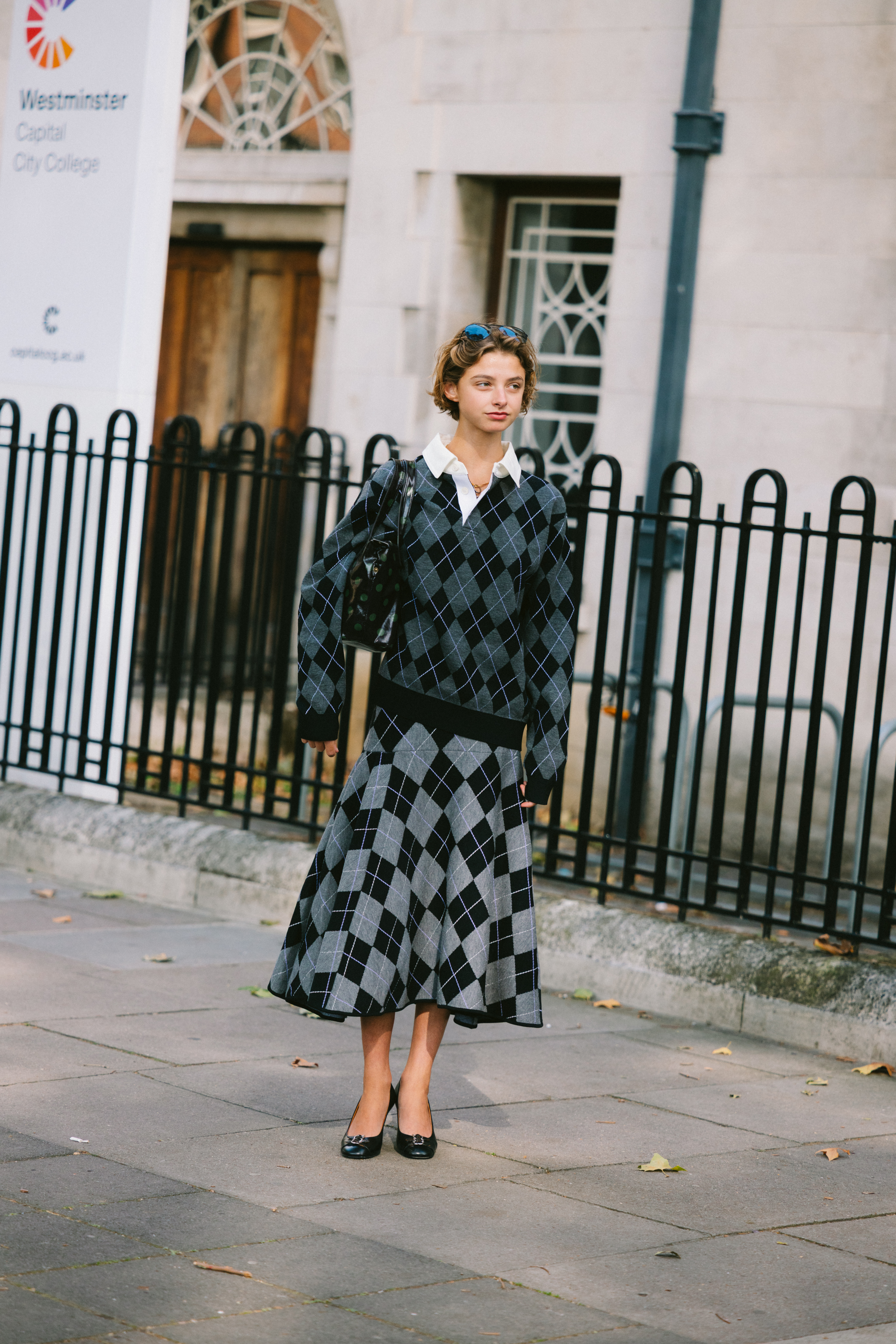 Woman wearing argyle sweater and argyle-print skirt during London Fashion Week.