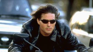 Tom Cruise as Ethan Hunt riding a motorcycle wearing sunglasses in Mission: Impossible 2
