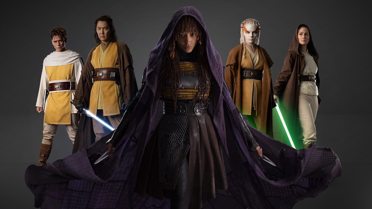 Five figures dressed in sci-fi costumes and two holding lightsabers
