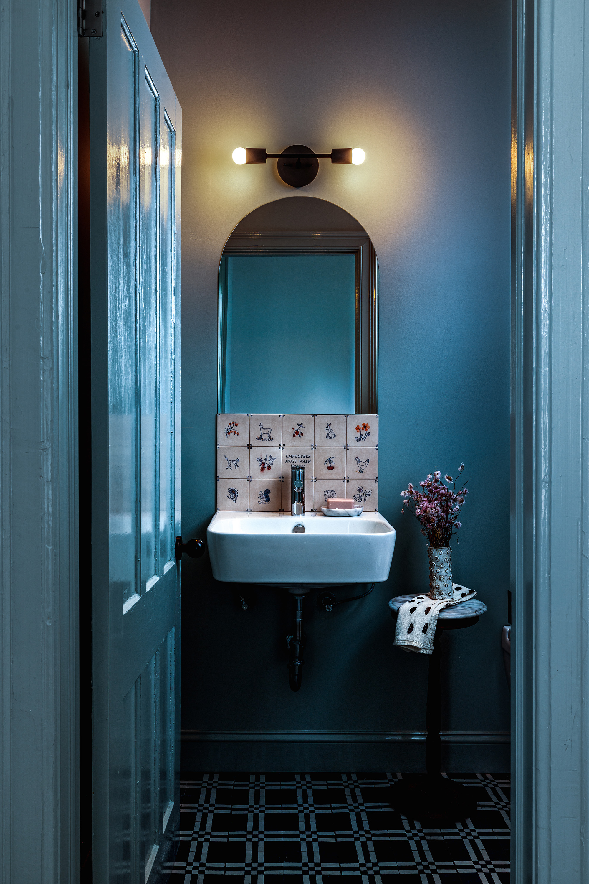 A powder room with aqua blue painted door and walls