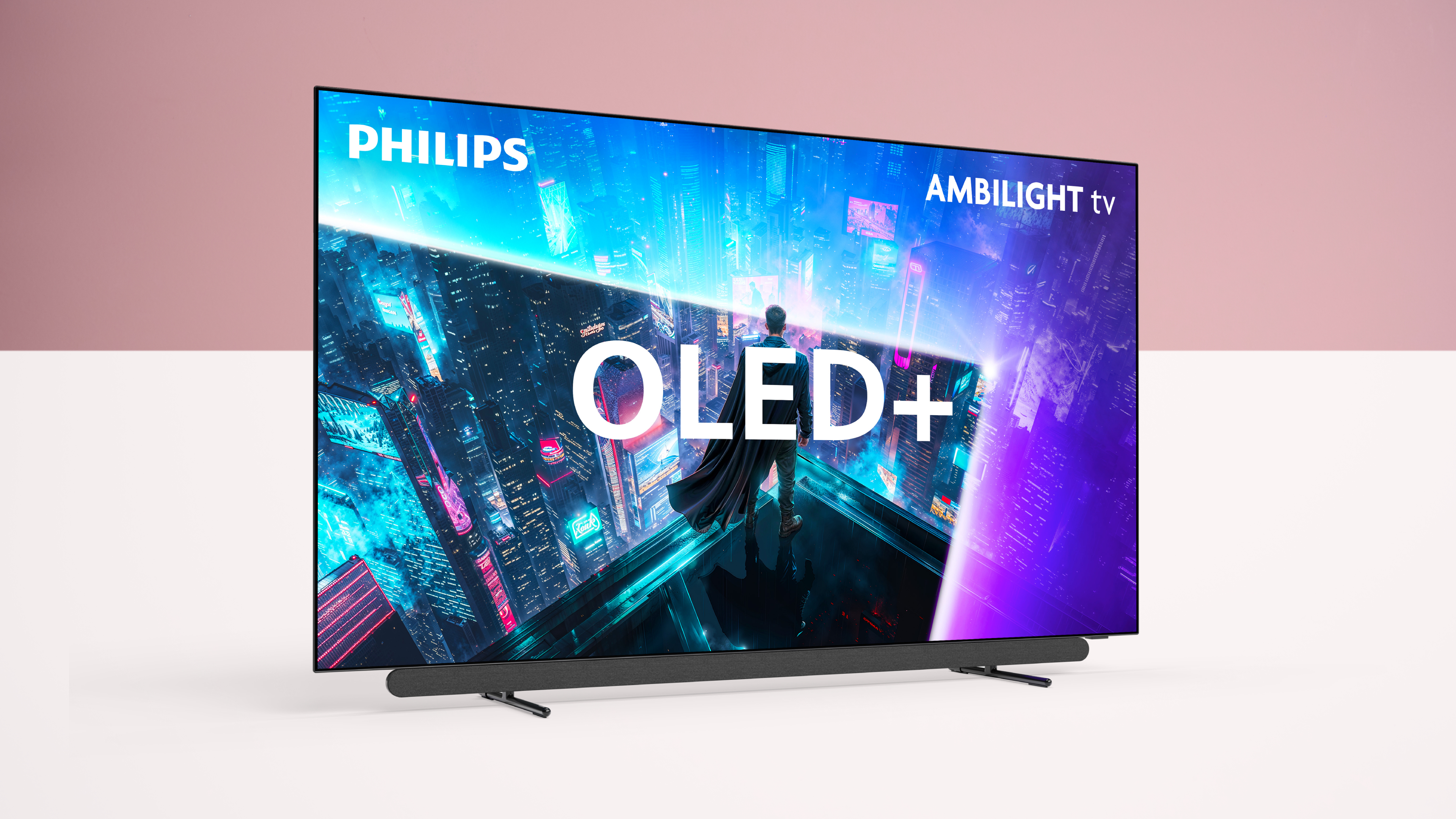The Philips OLED911 TV on a white surface, with a pink background. The TV says OLED+ on the screen