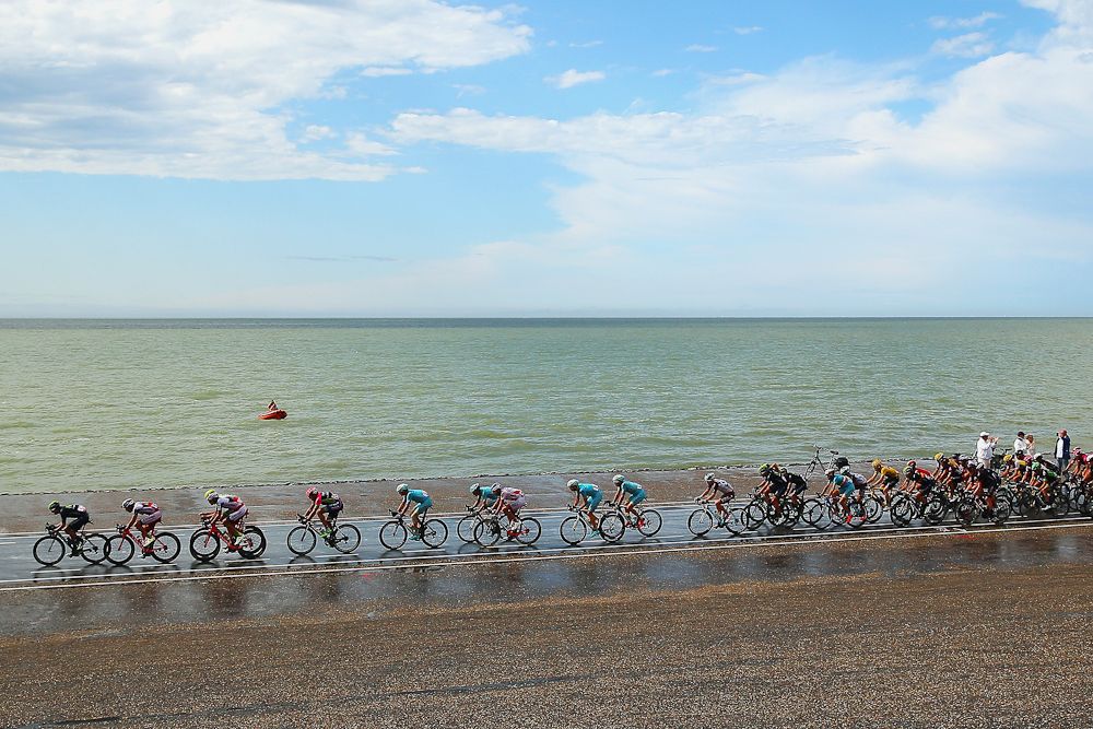 The peloton rides along the North Sea.