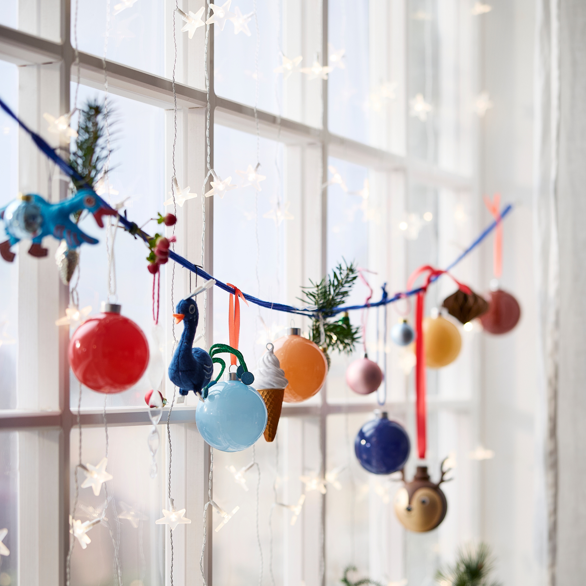 IKEA star fairy lights and baubles in a window.