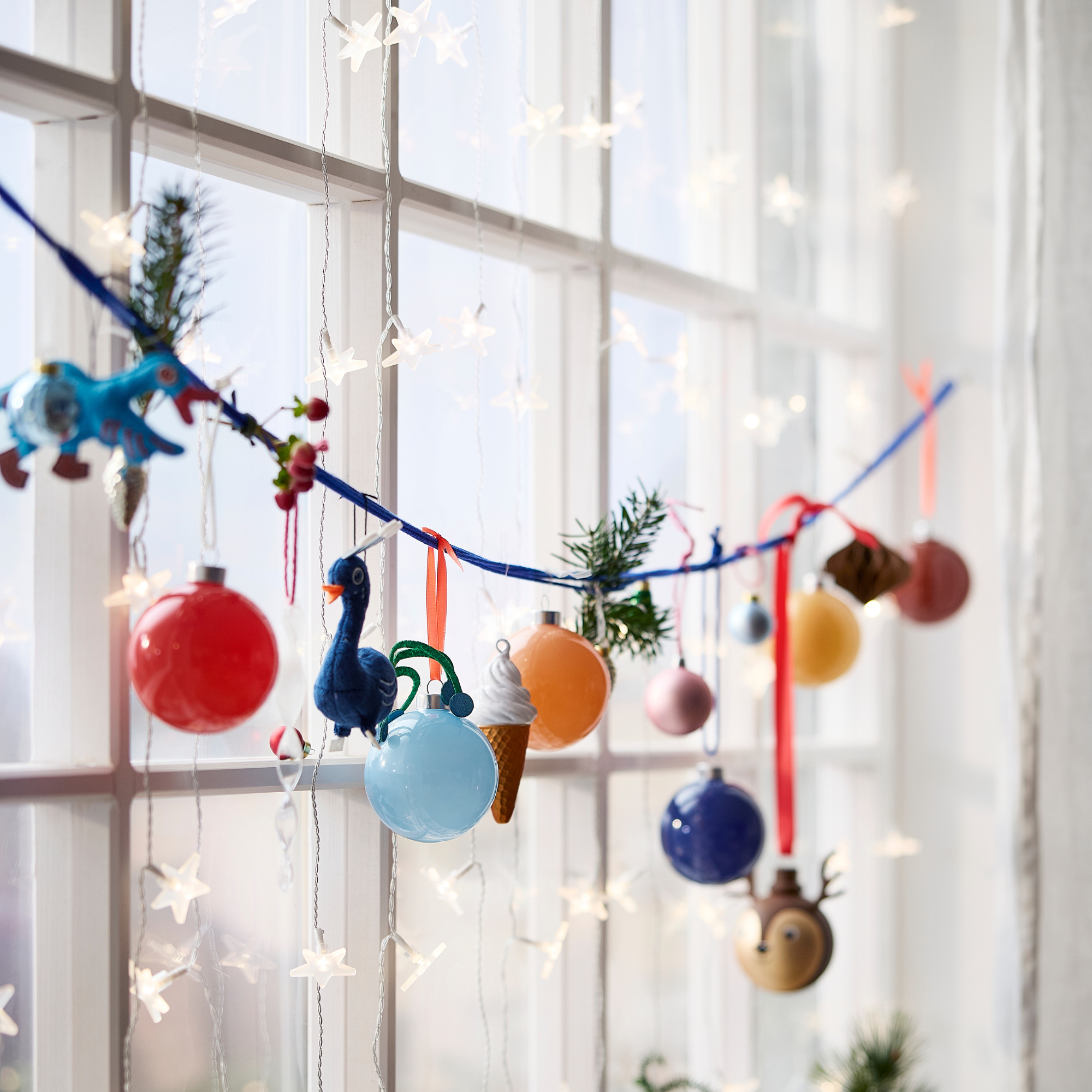 IKEA star fairy lights and baubles in a window.