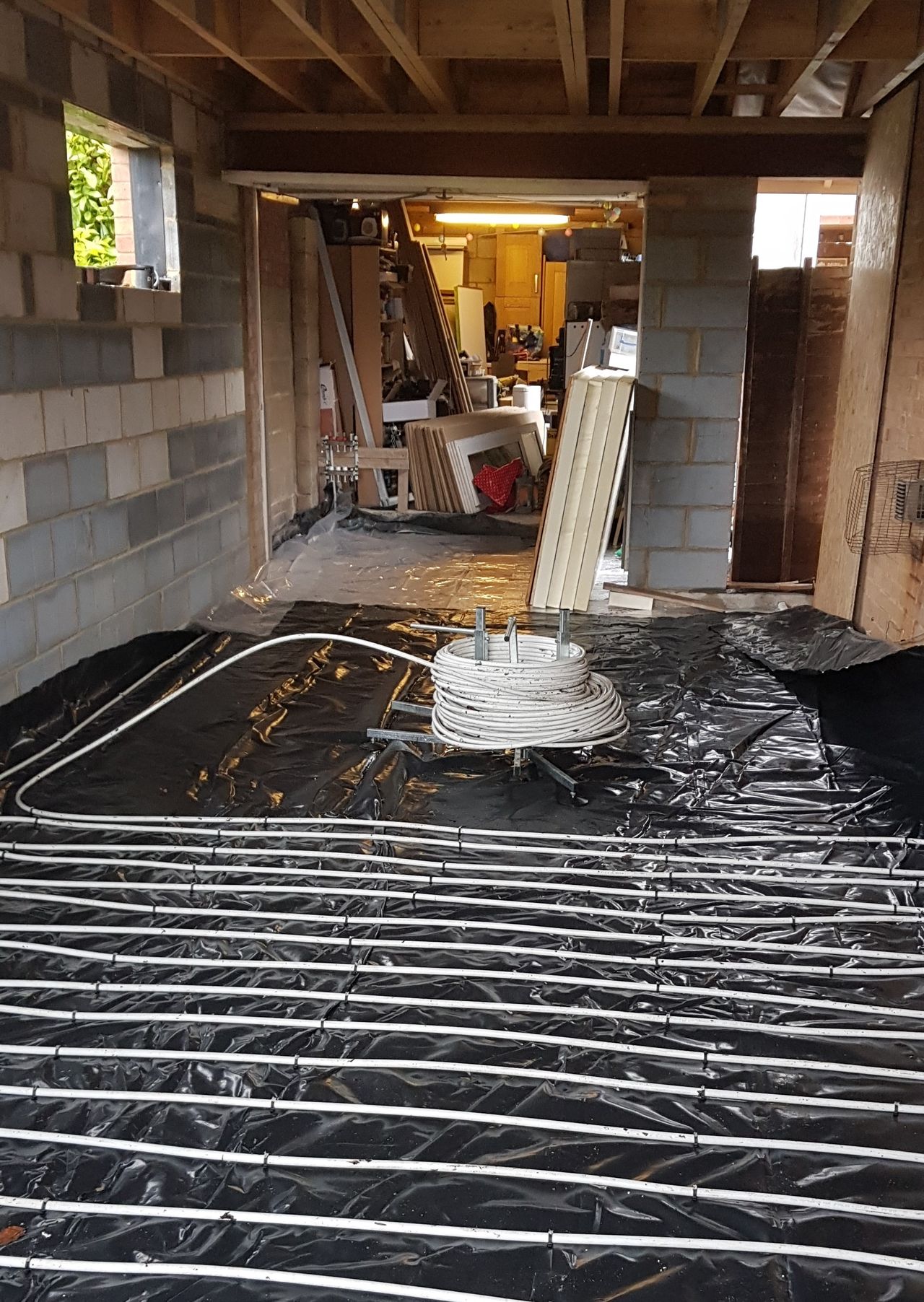 Black sheeting with underfloor heating pipes affixed to it in David Hilton's extension as it was built