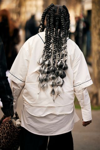 woman with braids and in a white shirt from the back