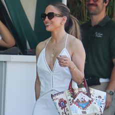 J.lo wears oversize sunglasses and a v-neck maxi dress.