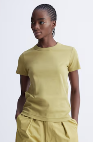 a model wears a yellow t shirt 