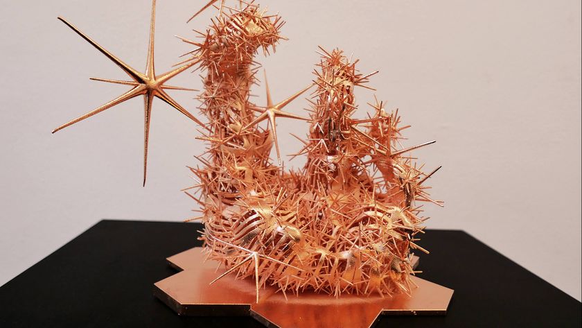 A series of golden metal sculpture and murals placed on white display tables or display walls as part of an art exhibit