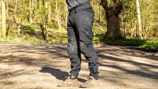 Man wearing Rapha Trail Gore-Tex pants with woods behind