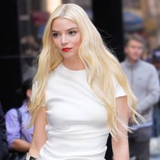 Anya Taylor Joy wears a white T-shirt and red lipstick with her hair down 