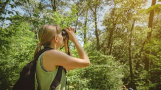 woman bird watching with binoculars at Indiana Dunes National Park