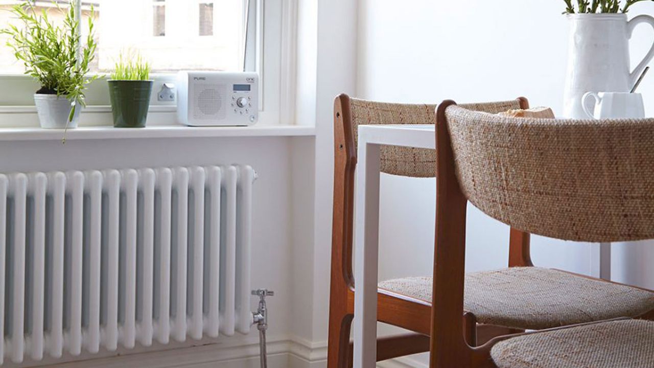 radiator in dining area with wooden chairs and window