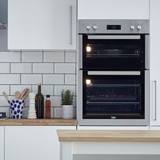 kitchen with white tiled wall and kitchen cabinets