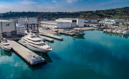 CRN's shipyard in Anoca, Italy featuring 8 yachts on varying sizes in the water. 