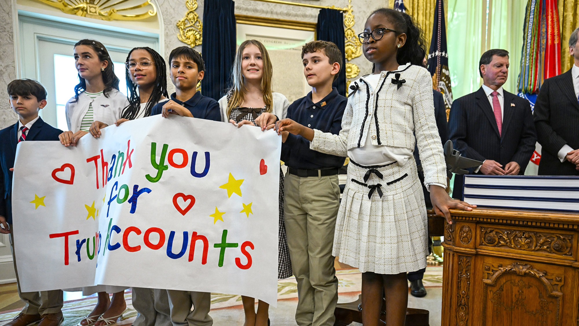 Children holding sign saying &lsquo;Thank you for Trump accounts&rsquo;