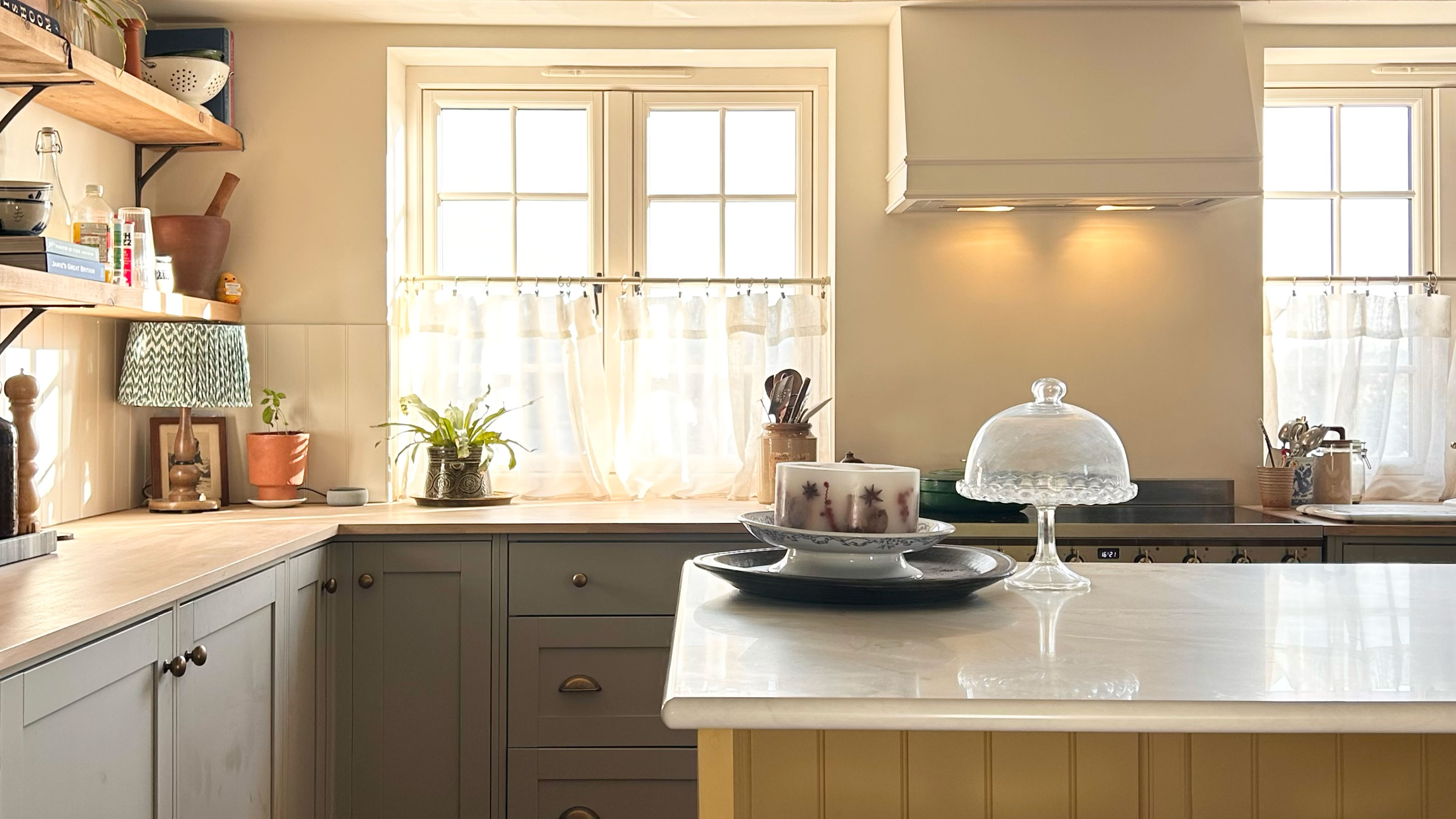 Kitchen with yellow panelled island, grey-blye cabinetry and wooden worktops