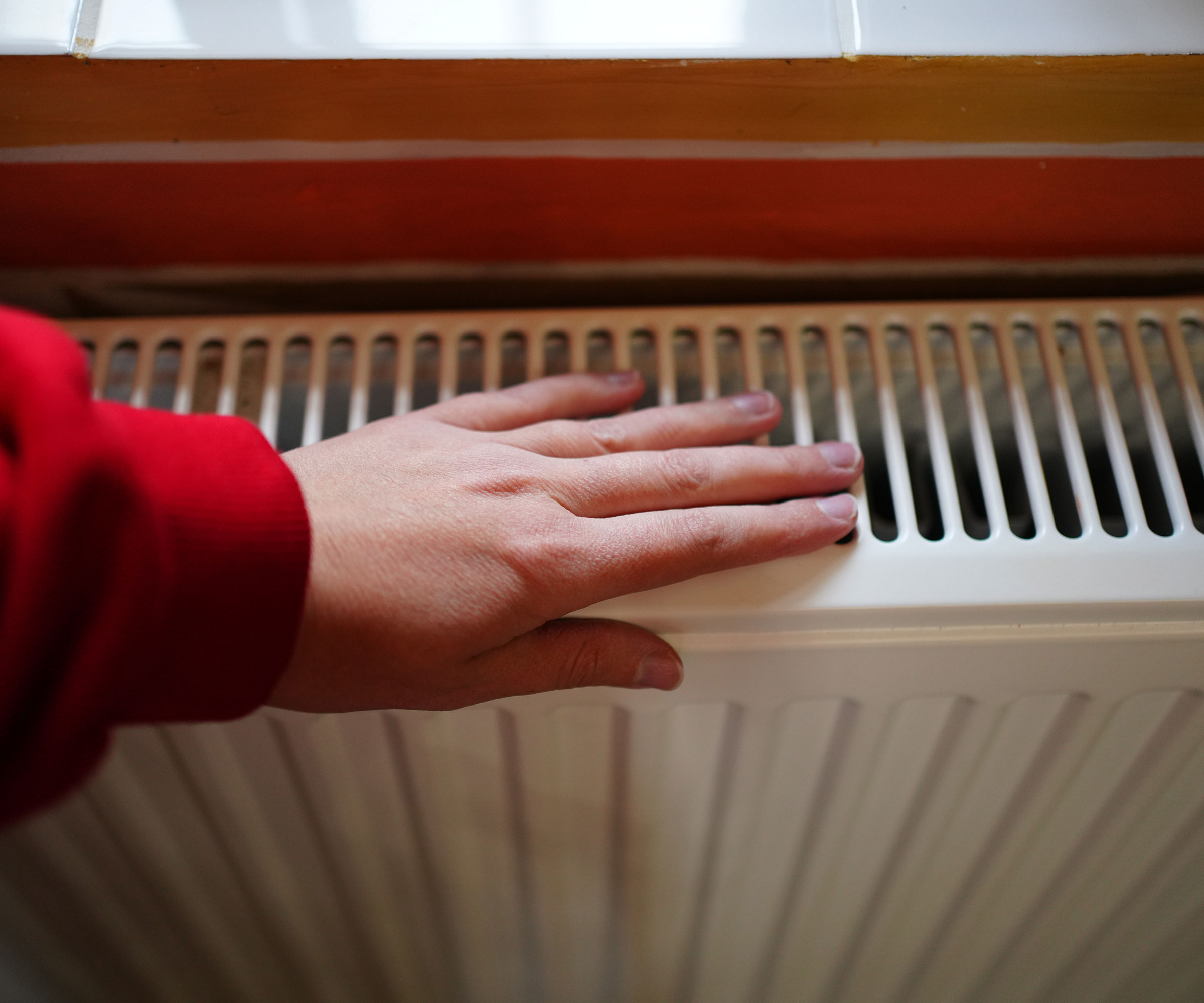woman&#039;s hand on radiator