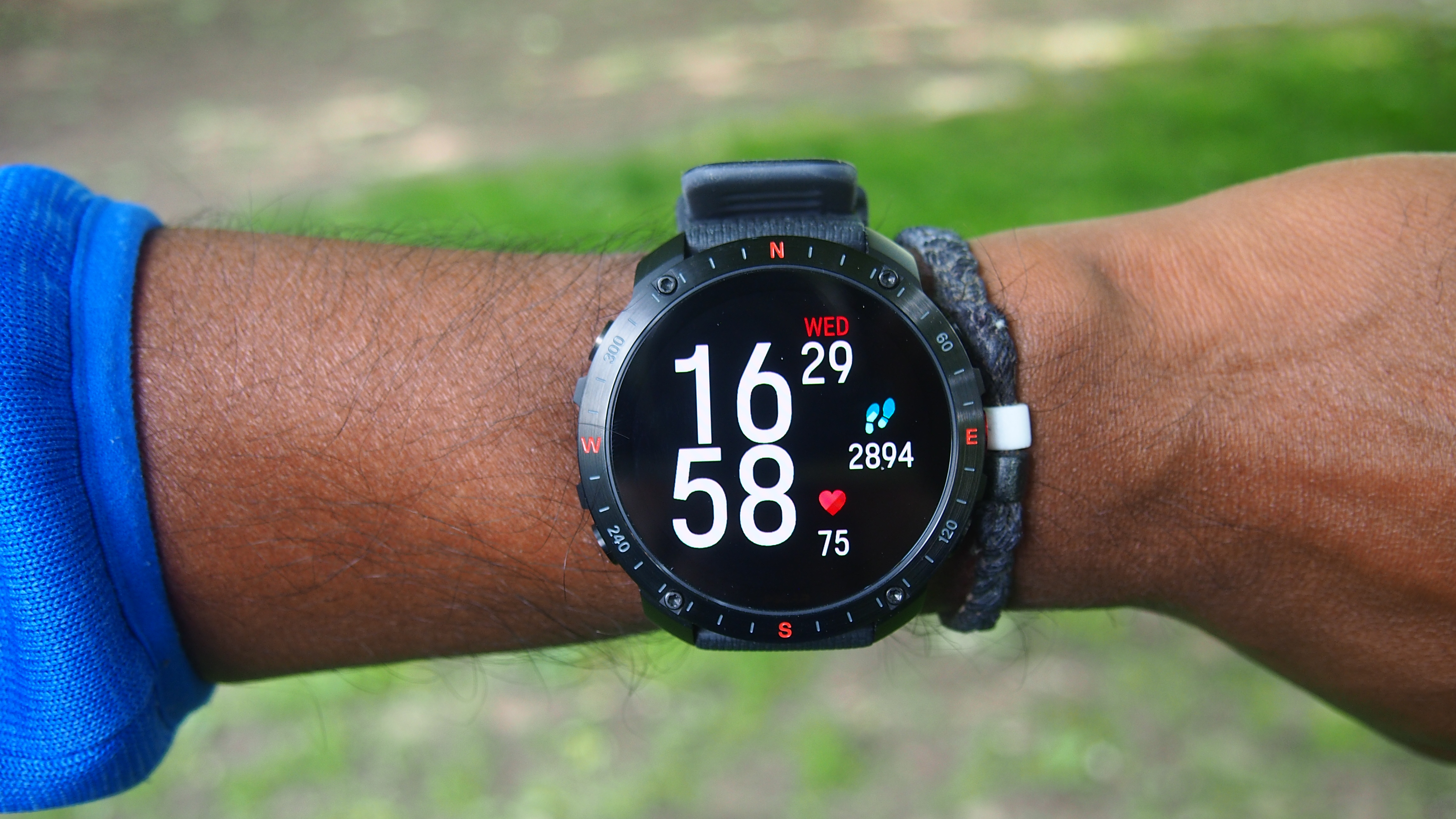 Polar Grit X2 Pro watch worn on the wrist with clock face and step count