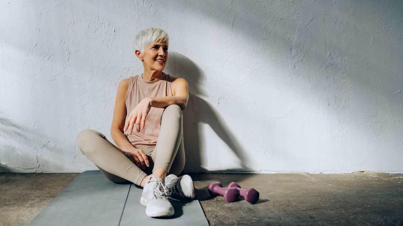 A woman on a yoga mat preparing to stretch