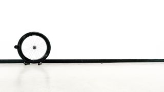 A pair of wheels lean against a white wall during out wind tunnel wheels test