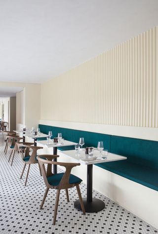 Restaurant with teal blue sofa seating and wooden chair