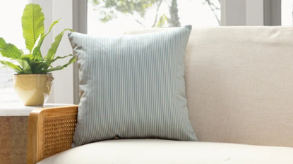 A striped cushion from the Wayfair sale positioned on a couch