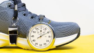 a gym shoe, whistle and stopwatch