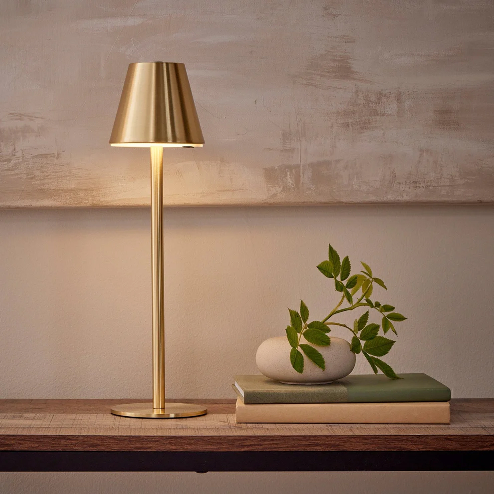 DUSK gold lamp on a wooden side table