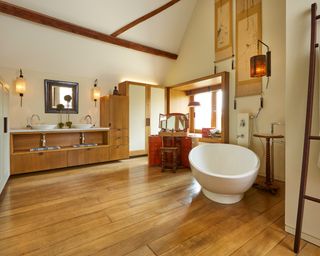 bathroom with wooden flooring, cupboard and tub
