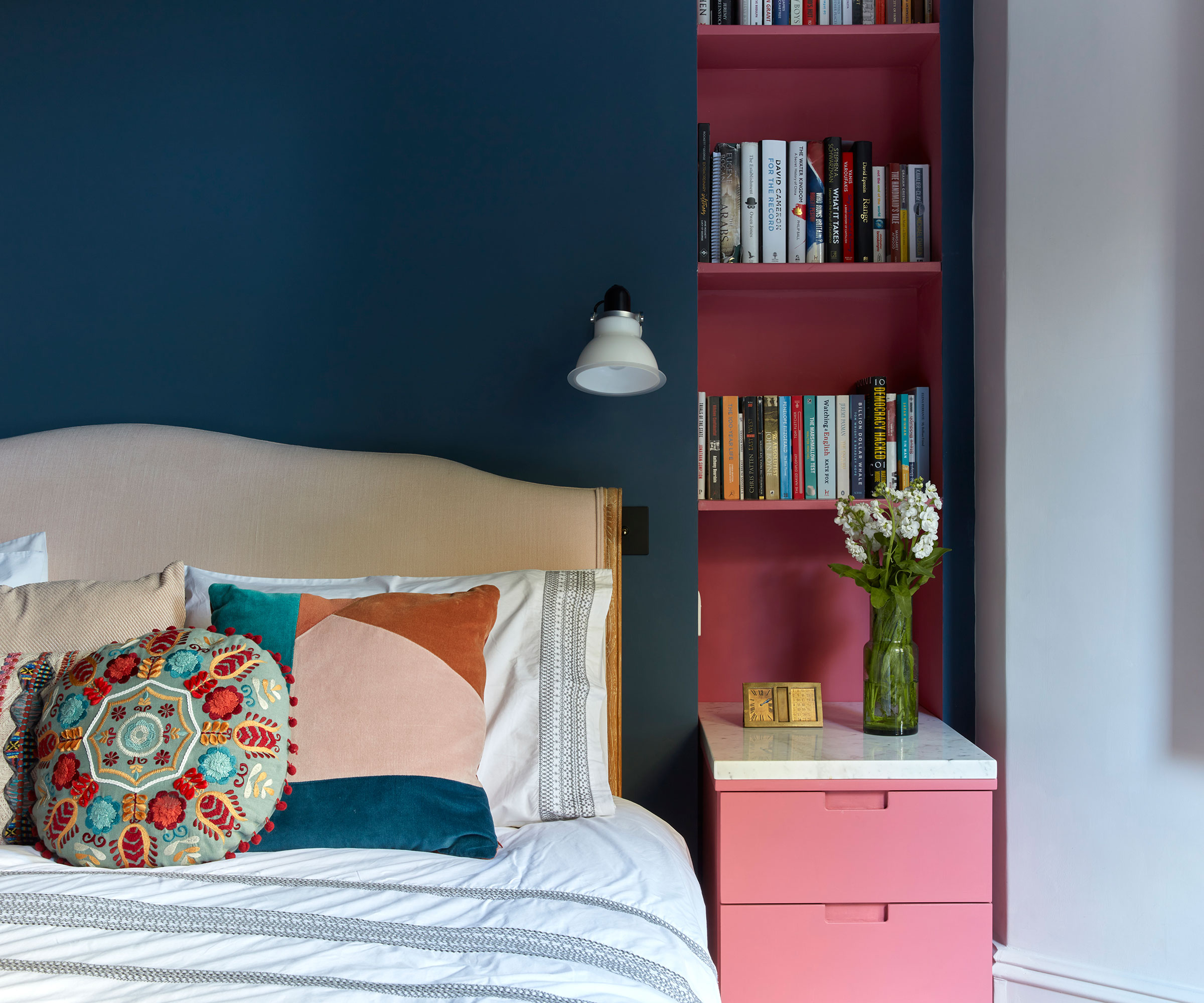 dark blue bedroom with red side table and shelving