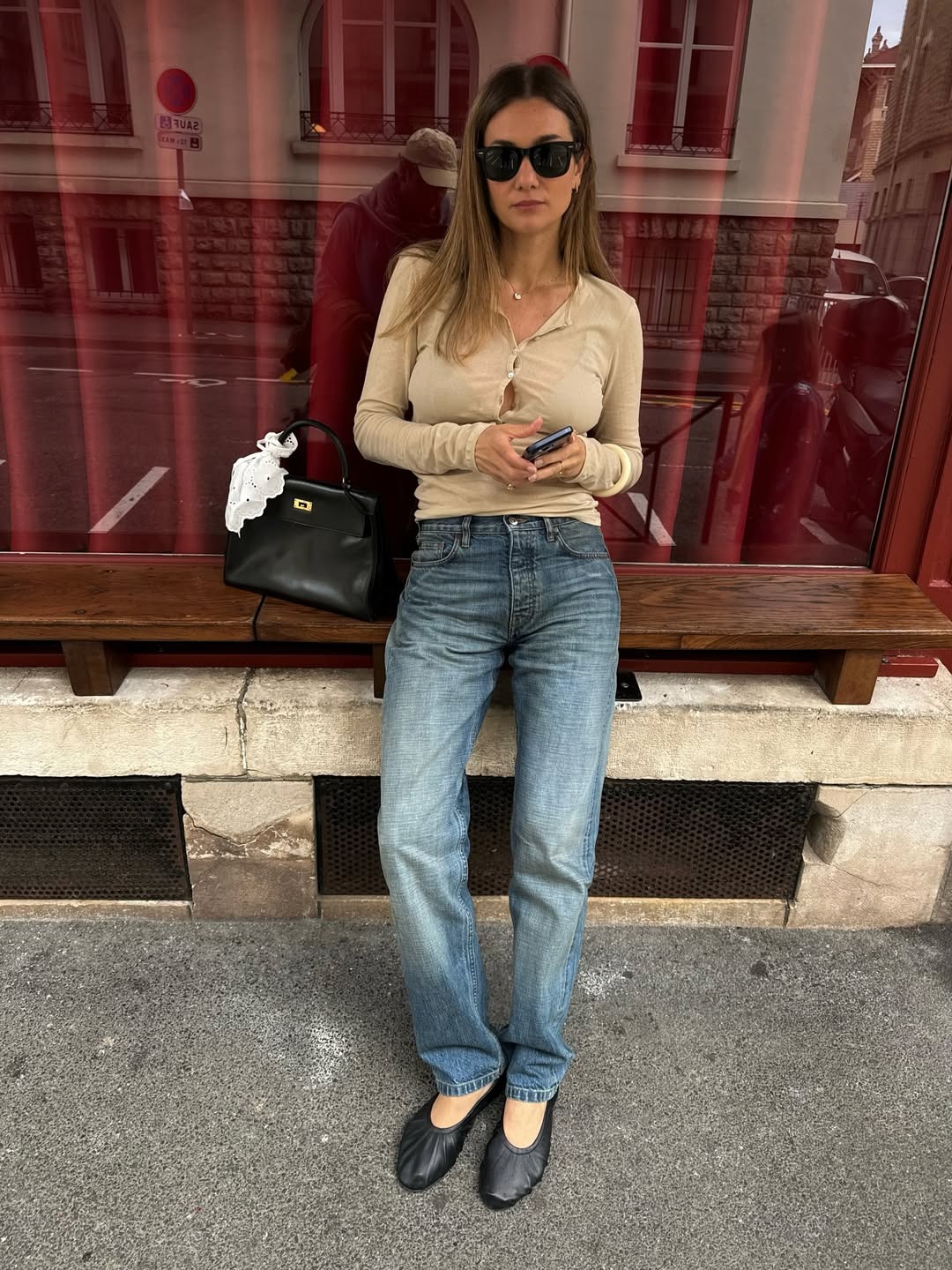 Woman in a cardigan, jeans and glove ballet flats