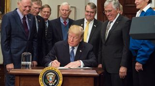 President Trump signs Space Policy Directive 1, instructing NASA to return humans to the moon, during a White House ceremony Dec. 11.