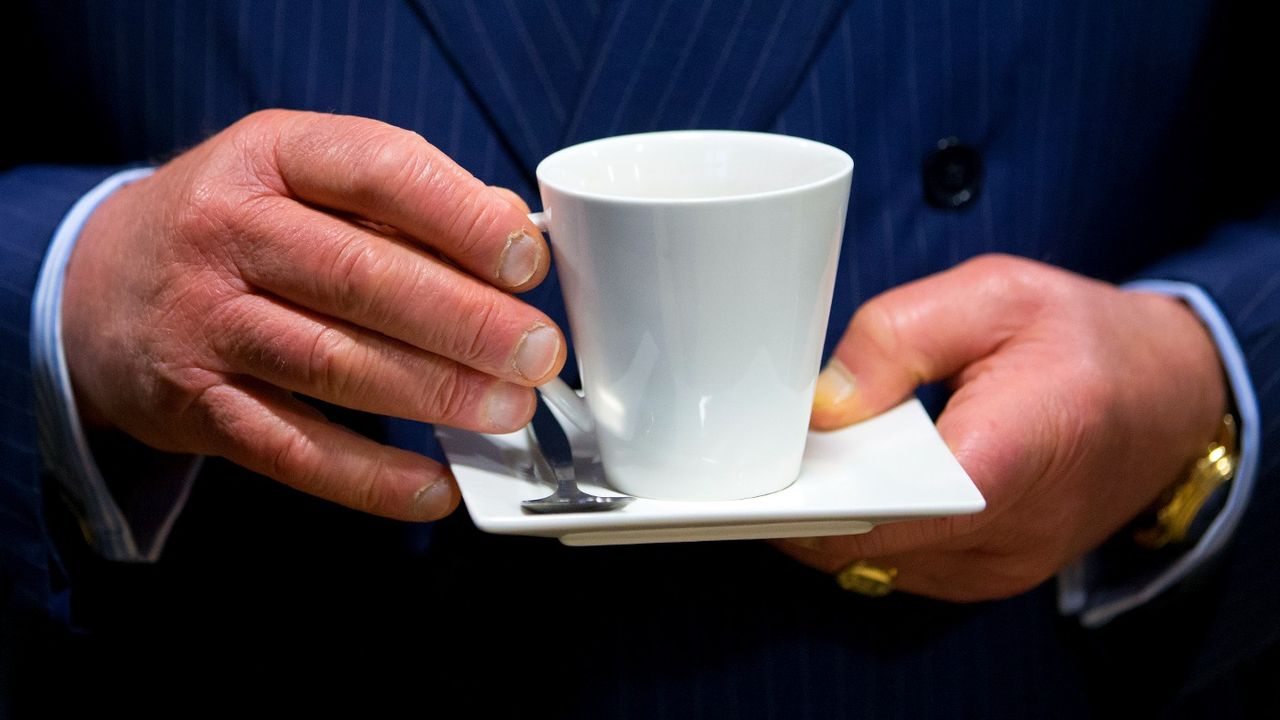 King Charles&#039; fingers holding a cup