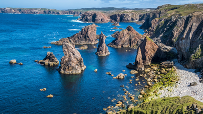 Rocks rise up from sea on coast of Scotland