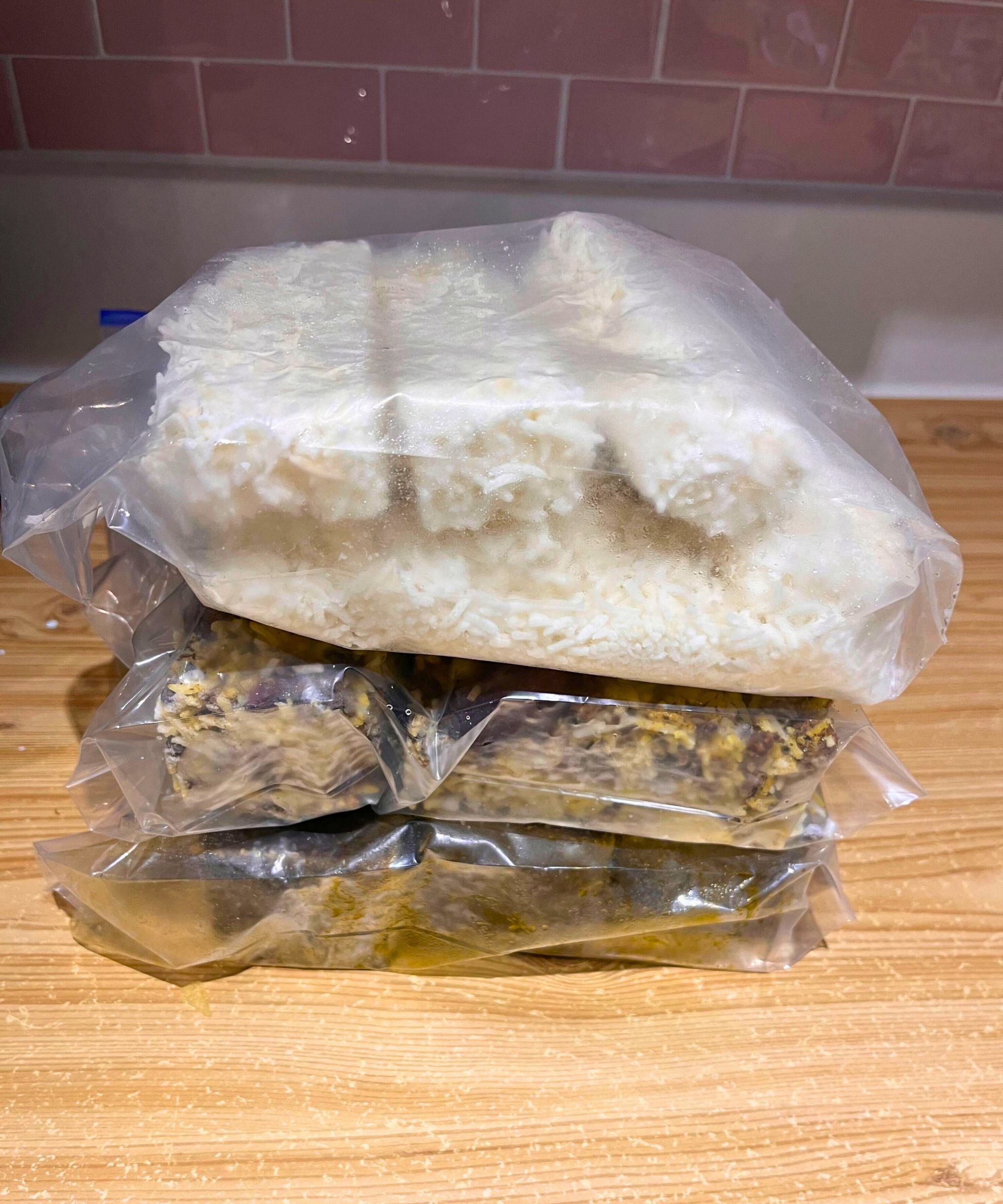 Three stacked blocks of Persian food in non-toxic freezer bags. It's space-saving and neat as the same amount of food would have required three or four food containers.