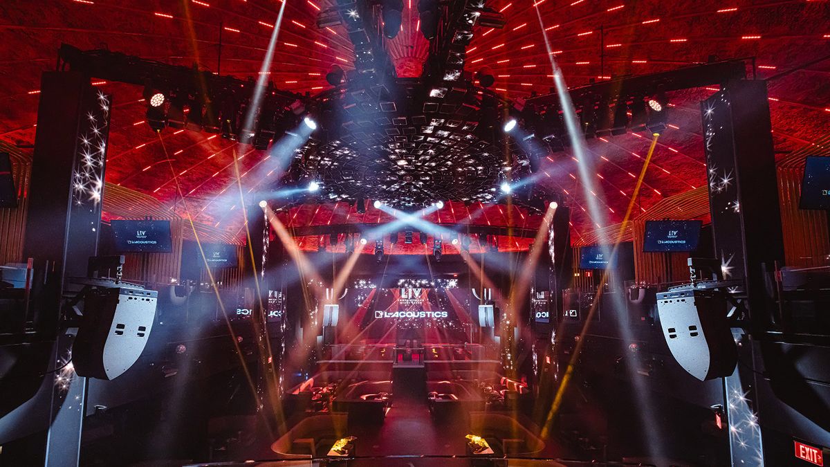 Lights beam across a red-lit stage at LIV Nightclub at Fontainebleau Miami Beach.