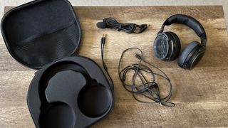 Corsair Virtuoso Pro headset with cables and carry case on a wooden table