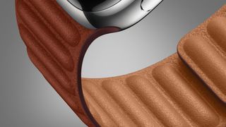 A leather Apple Watch band on a grey background