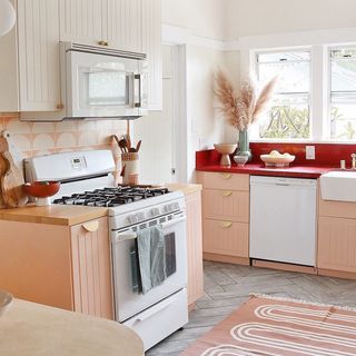 Modern, playful kitchen with scalloped patterns and details, and soft coral cabinets.